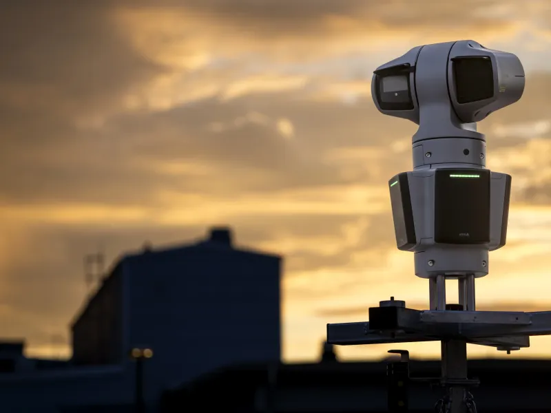 PTZ surveillance camera monitoring an industrial site at dusk